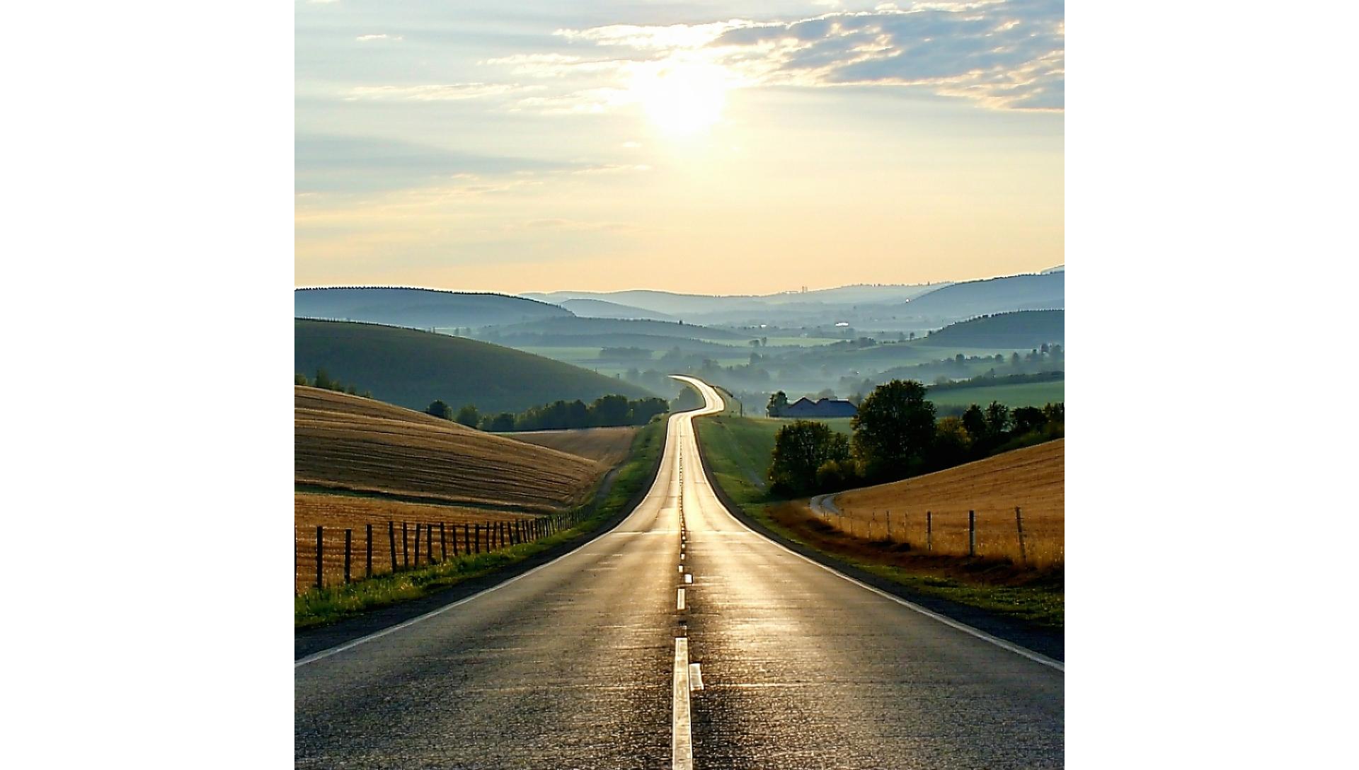 A serene highway winding through the Czech countryside at sunset, symbolizing smooth and unrestricted travel.